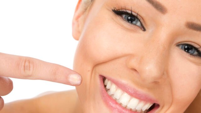 woman pointing at her smile