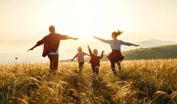 Happy family: mother, father, children son and daughter on nature on sunset