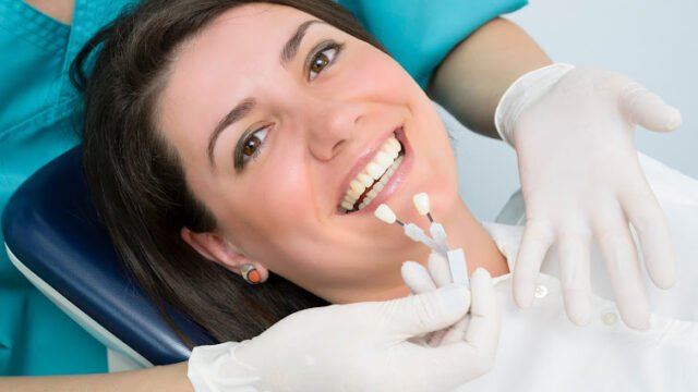 A dentist showing porcelain teeth to pacient
