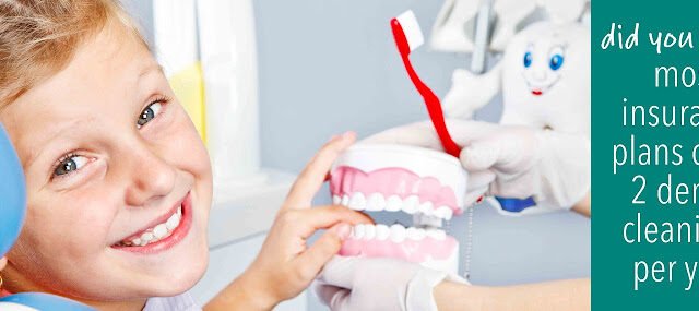 Happy child playing with toy dentures in dental office